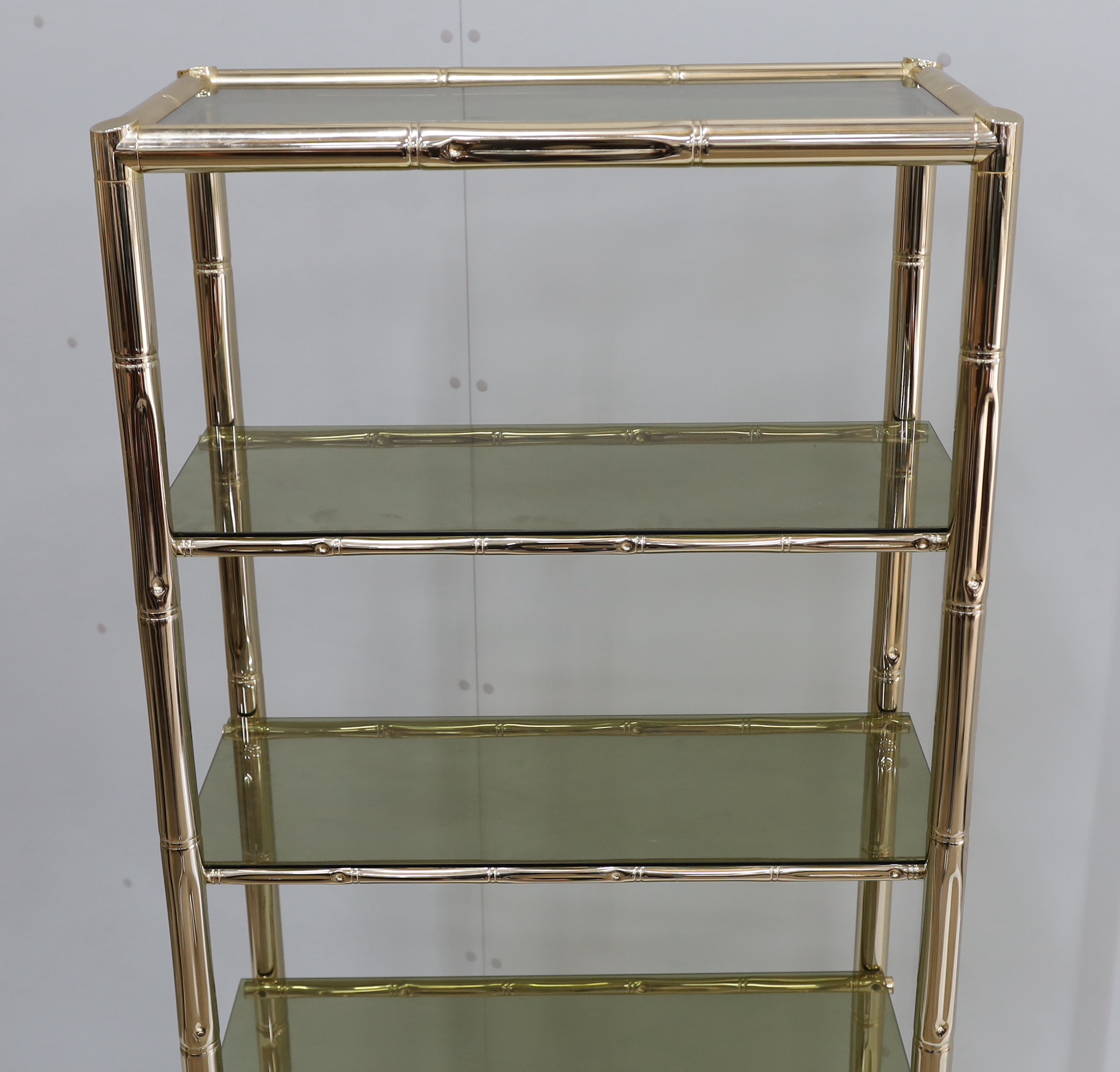 A Maison Jansen style faux bamboo brass and smoked glass five tier shelf unit, width 76cm, depth 39cm, height 180cm